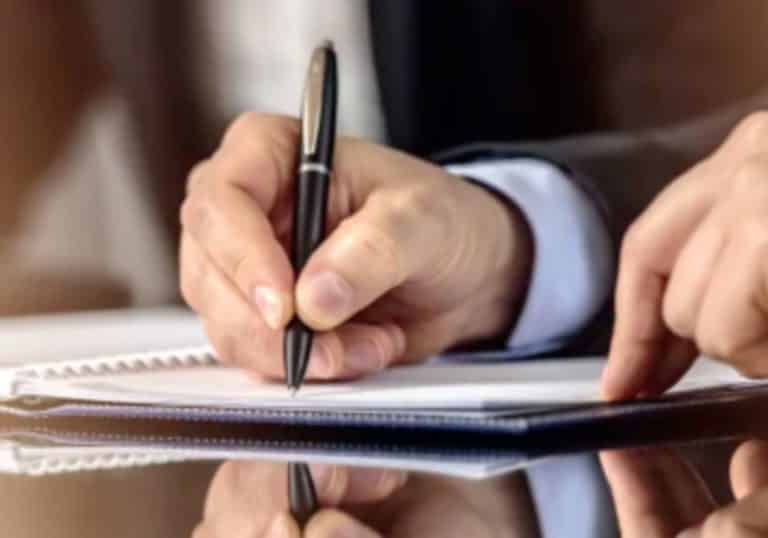 Photo of a hand signing a document to represent document completion for law firms