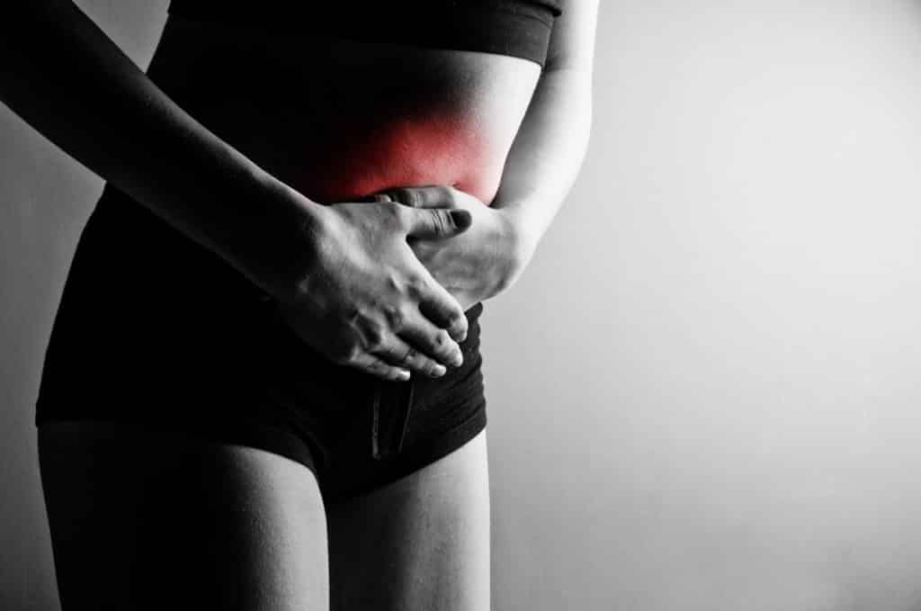 Photo of a woman holding her abdomen in pain